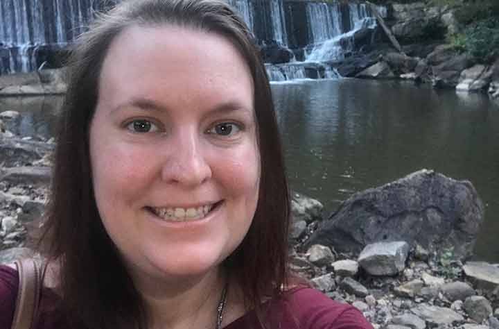 Britanny smiles in front of waterfall.