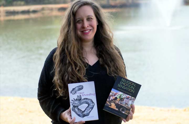 Professor and Author Karen Bray holds up her books.