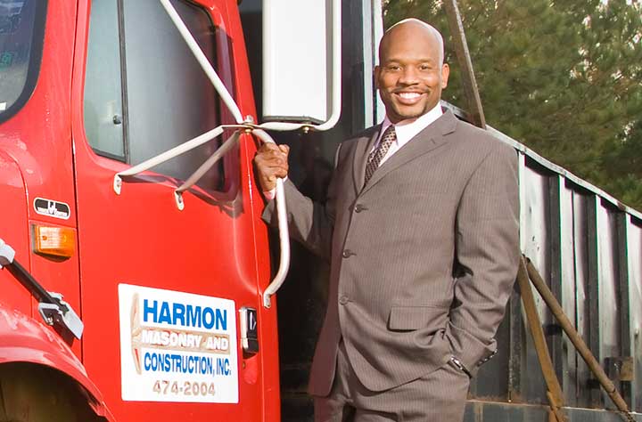 Adrian Harmon stand with his company truck.