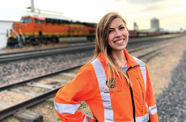 Kyla Burns stands outside in front of train.