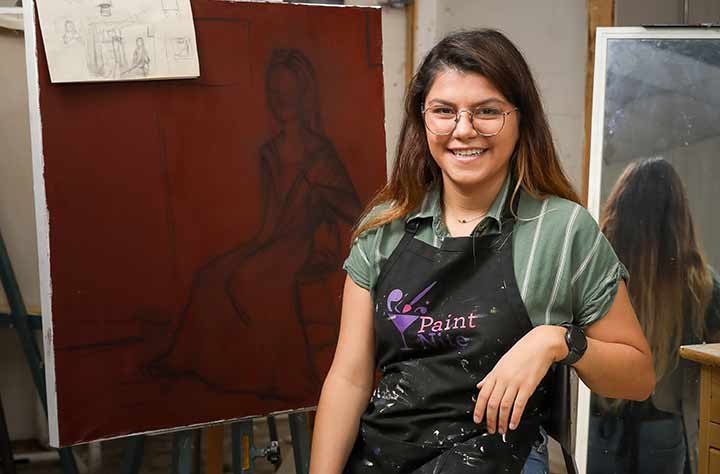 Labinalis in front of her painting in the art building.