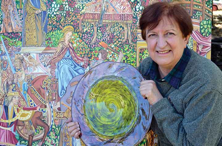 Elizabeth Bailey holding her award in front of her artwork