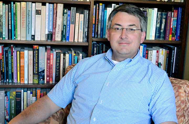 Nicholas J. Steneck sitting in his office in front of bookcase