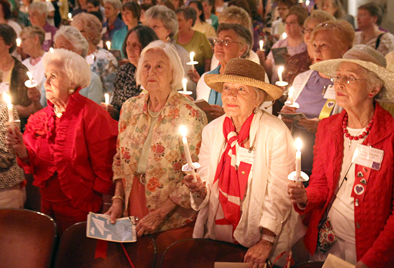 Alumnnae hold candles during ceremony in Porter