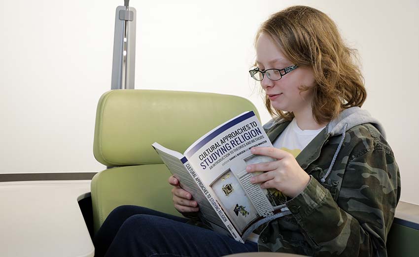 Student reading book on religion studies