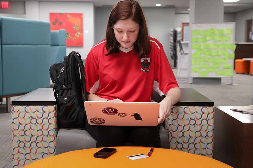 Student in studying in Willet Library on her laptop.