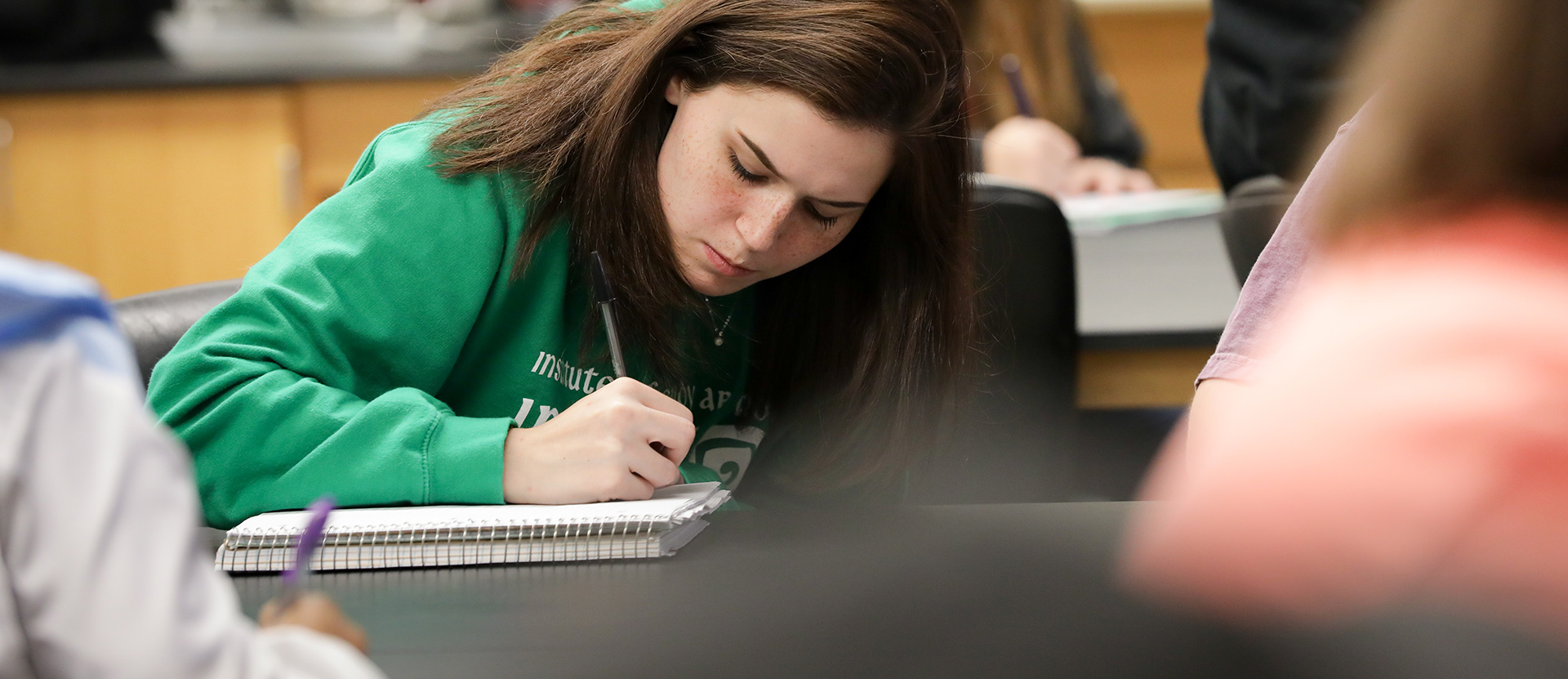 Student writing notes in classroom