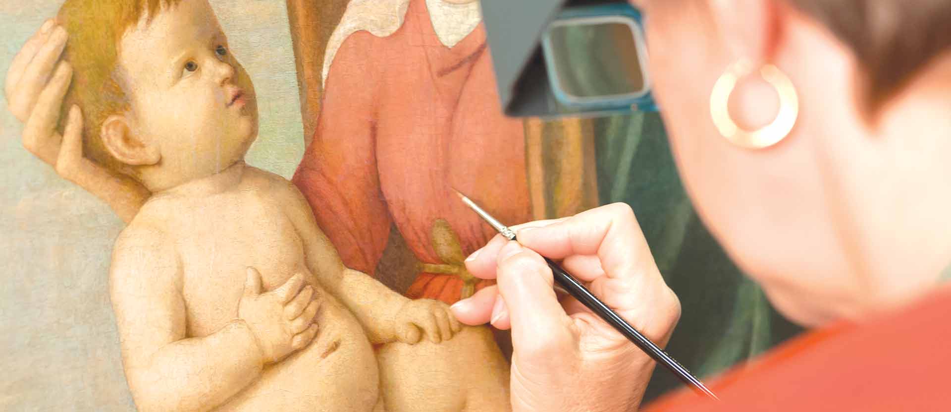 Woman repairing painting of baby with very small paintbrush.