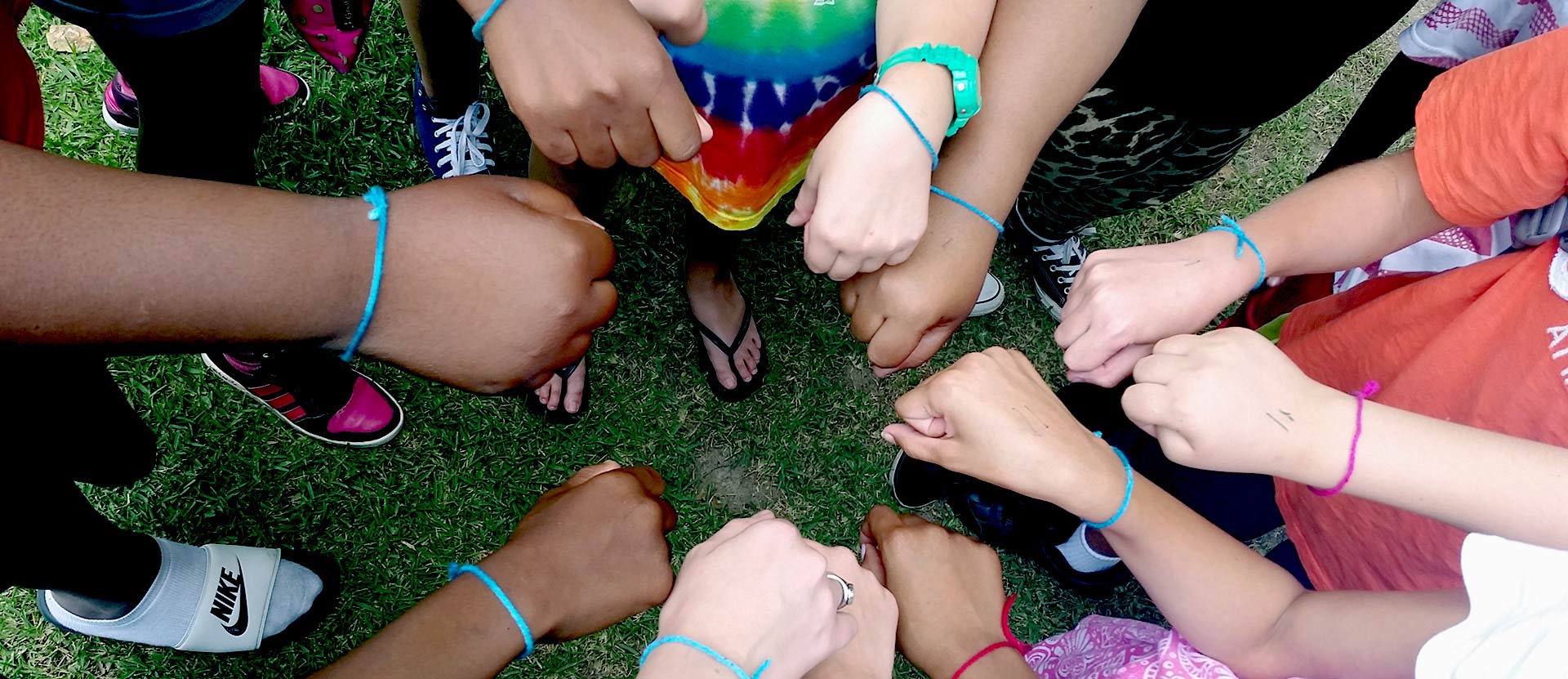 Children in a circle with their hands out.