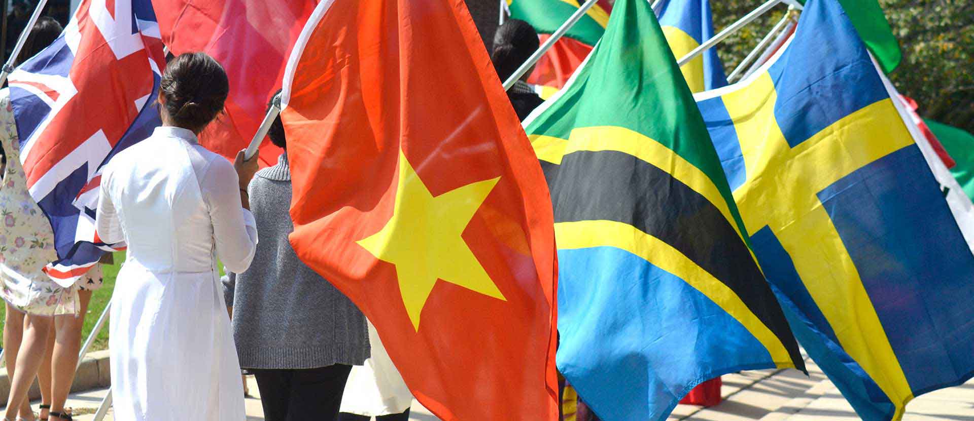 Students carry their countries flags during Fall Convo celebration