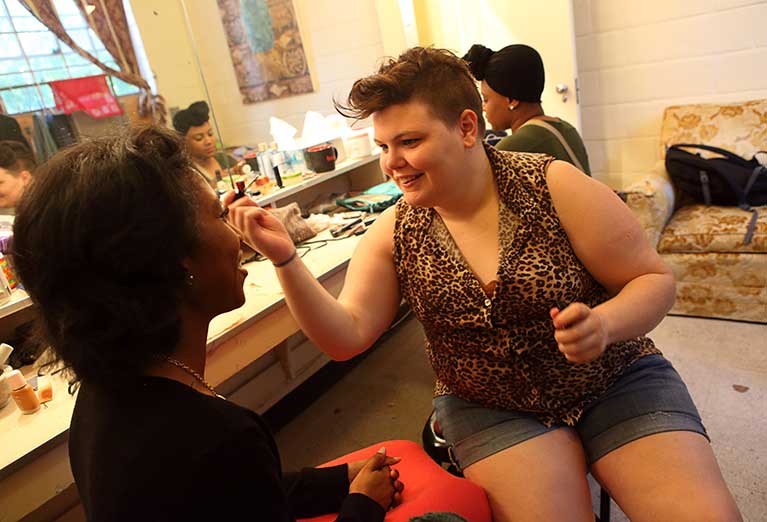 Students get ready before theatre production, applying makeup and getting in character.
