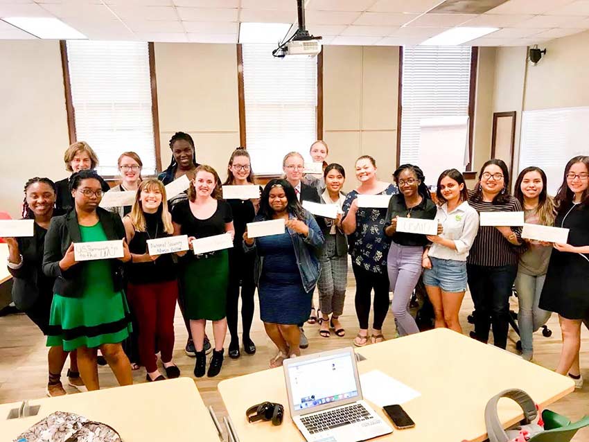 Model UN Students hold signs.