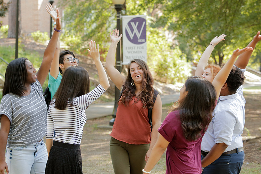 Students celebrate with hands up in the quad